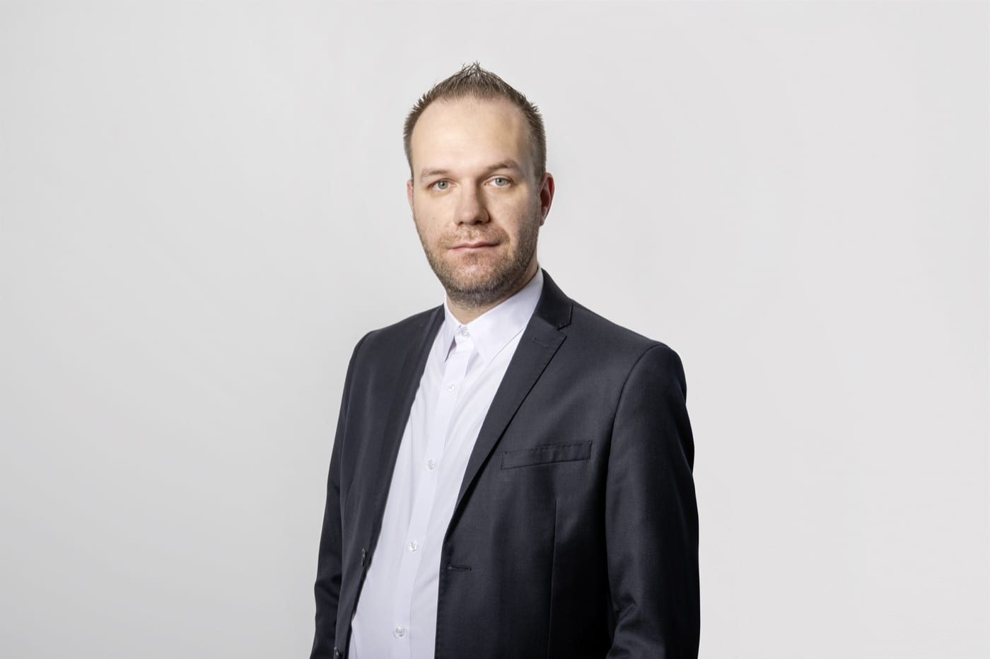 Robert Roth im dunklen Sakko vor hellem Hintergrund